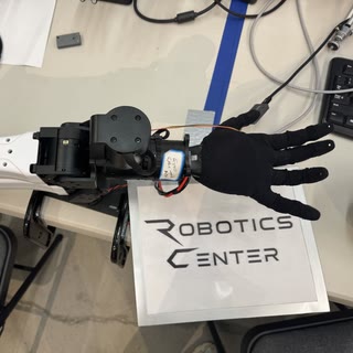 Robot arm and dexterous hand mounted above the pick and place benchmark work surface